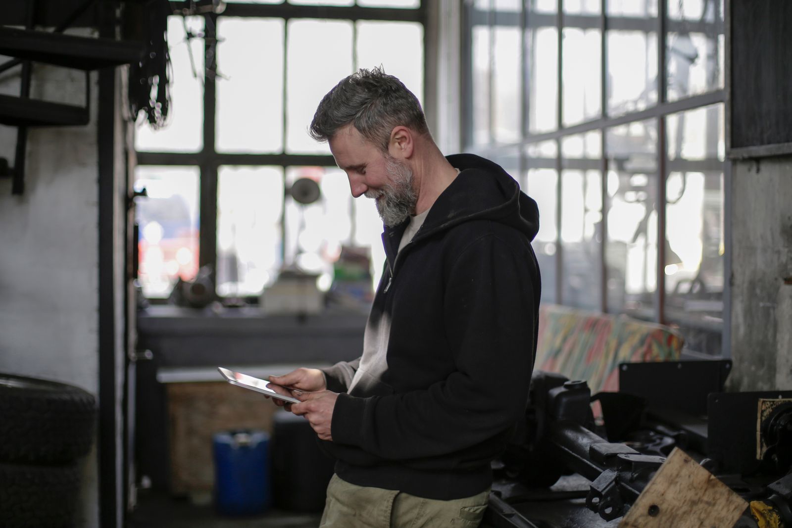 A worker in a workshop checking a tablet