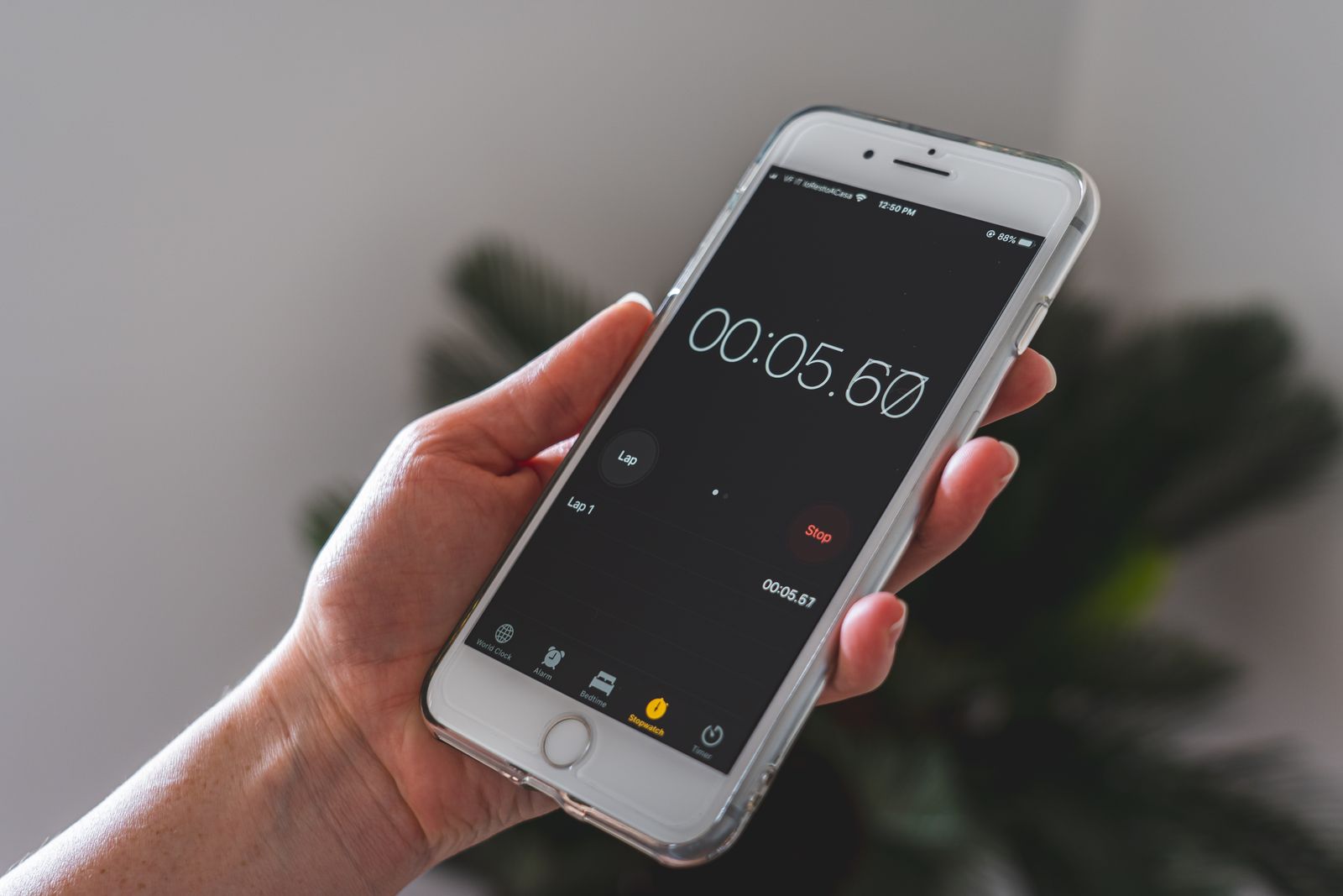 A hand holding a phone showing a stopwatch app